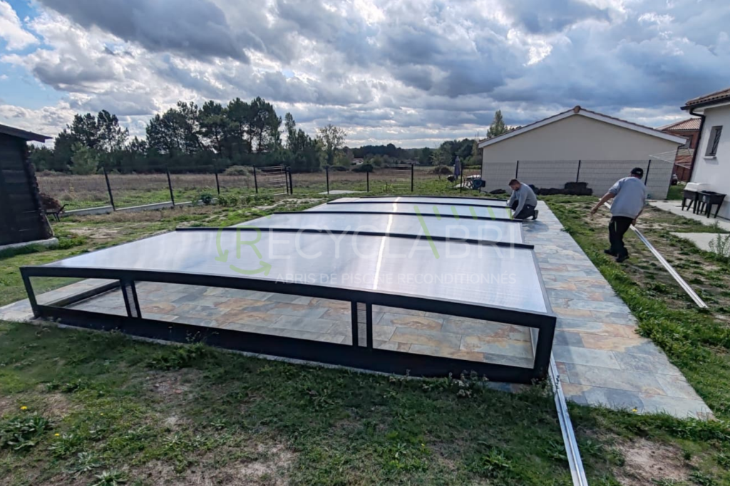 Installation des différents modules sur l'abri de piscine bas gris anthracite reconditionné