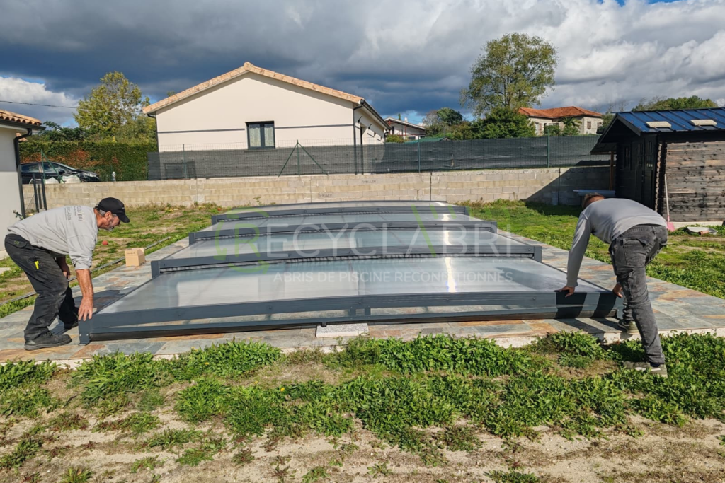 Deux poseurs installent un module de l’abri gris anthracite